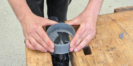 Deckel eines Plastikrohrs wird mit einer Stichsäge entfernt.